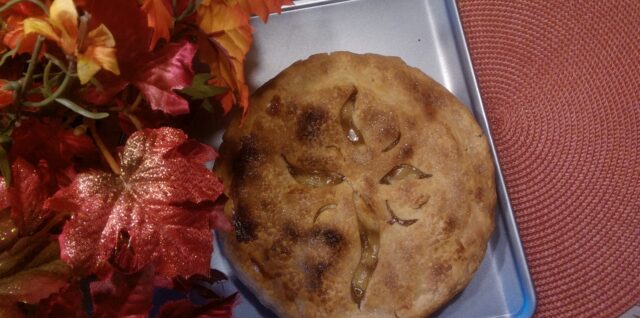 A fresh-baked pie with an artistic decoration on the crust.