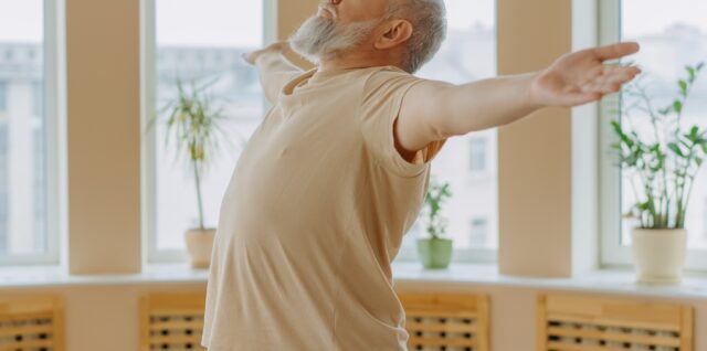 older man arms outstretched breathing deeply