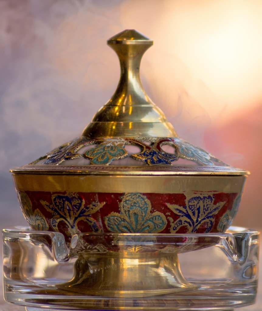 red gold incense burner in glass ashtray